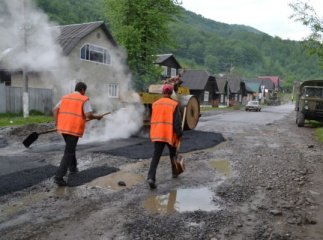 Чергова недбалість дорожників: асфальт у калюжі, а поверх нього вантажівки (ФОТОФАКТ)