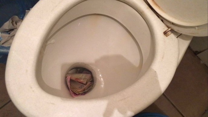 Гроші в унітазі та умивальнику: оприлюднено фото із затримання прикордонника-хабарника – 01