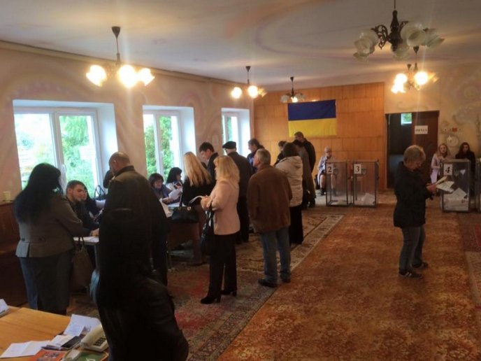 На одній із дільниць в Росвигові люди стоять в черзі, щоб віддати свій голос – 02