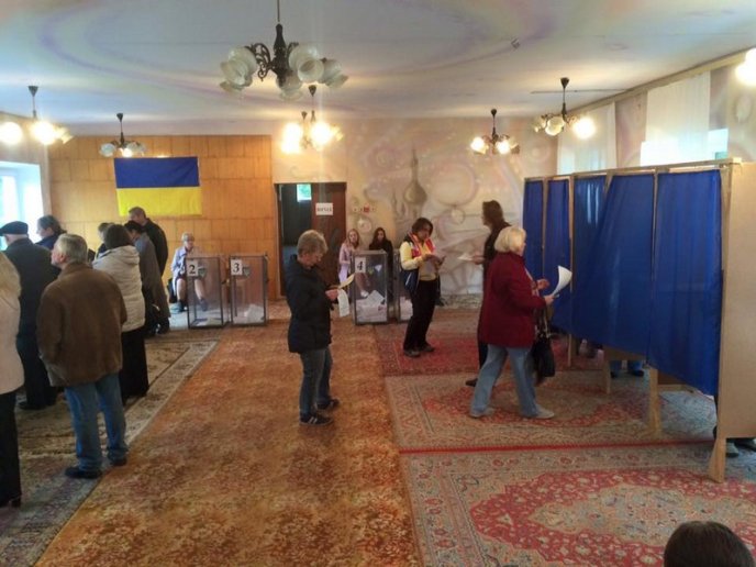 На одній із дільниць в Росвигові люди стоять в черзі, щоб віддати свій голос – 01