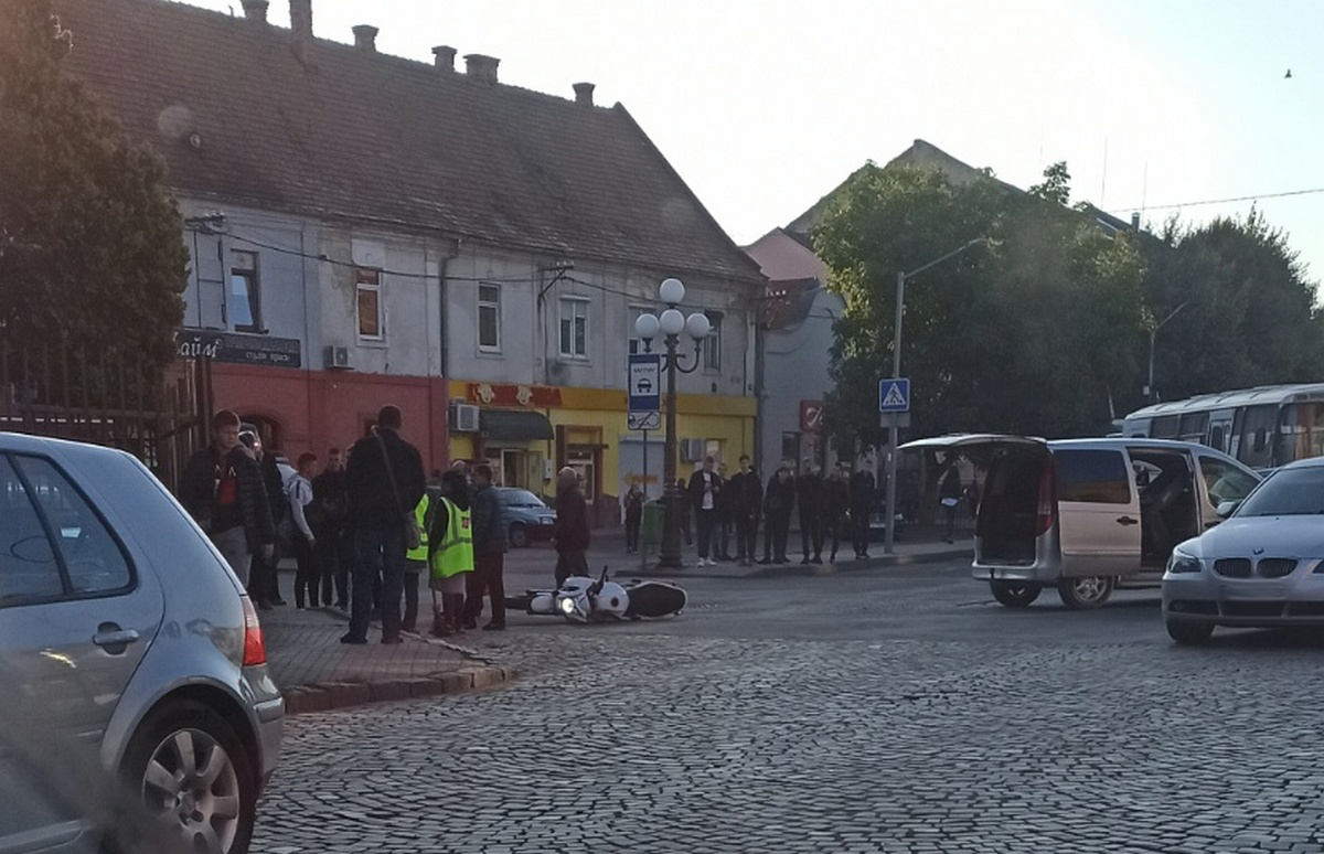 Ранкова ДТП у центрі Мукачева: на місці зібрались люди, видно перекинутий мотоцикл Ранкова ДТП у центрі Мукачева: на місці зібрались люди, видно перекинутий мотоцикл